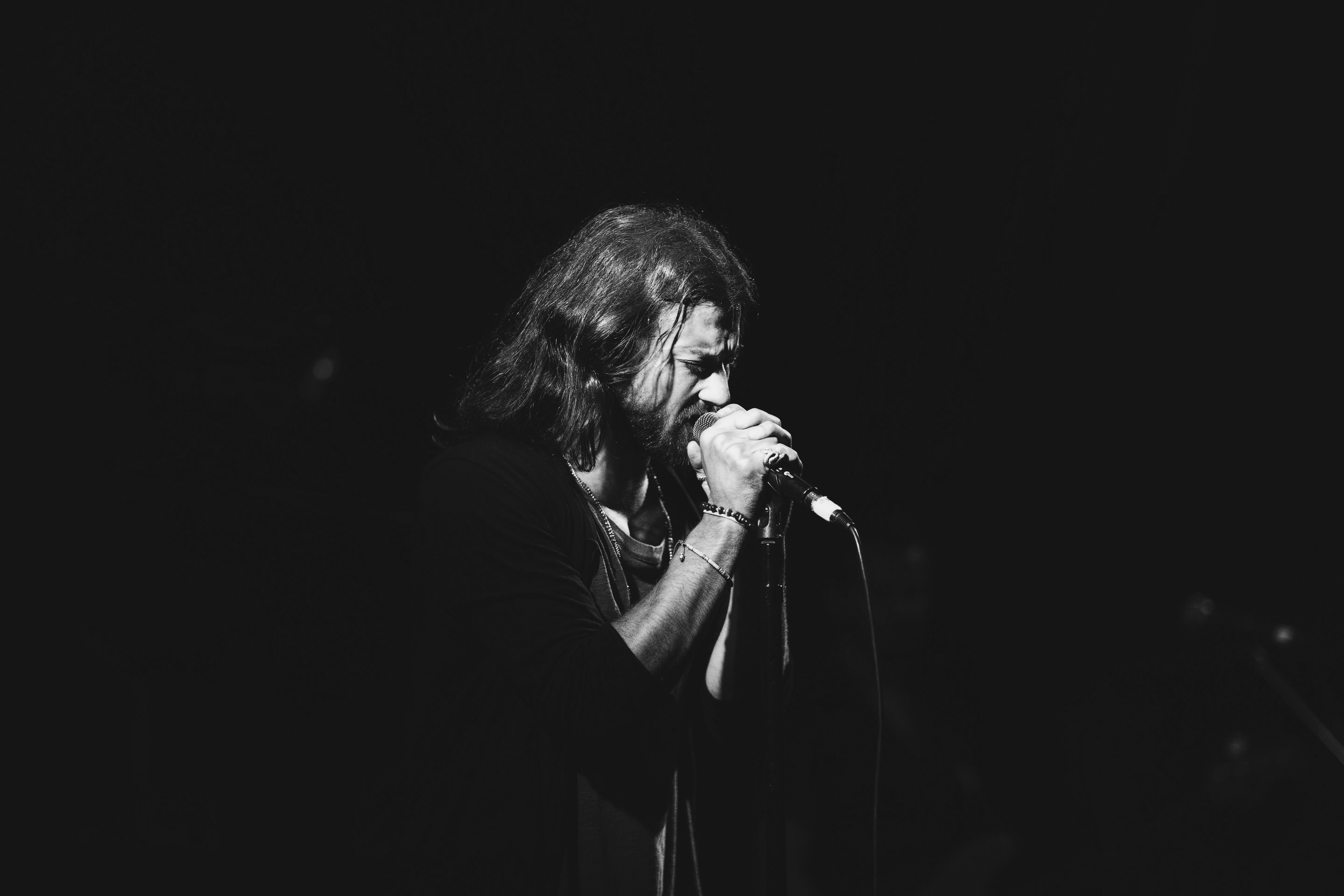 man using microphone in dark surface